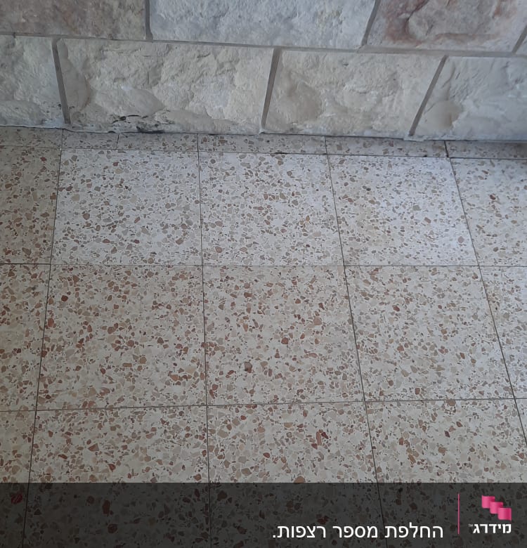 רצפת אריחים עם קיר אבן, סימני שחיקה בתחתית הקיר